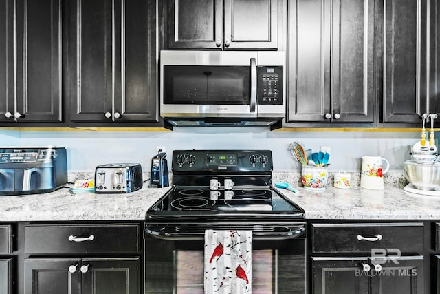 kitchen with light stone countertops and black range with electric cooktop