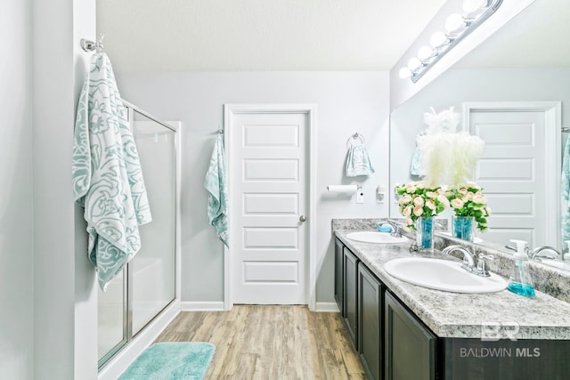 bathroom featuring vanity, an enclosed shower, and wood-type flooring