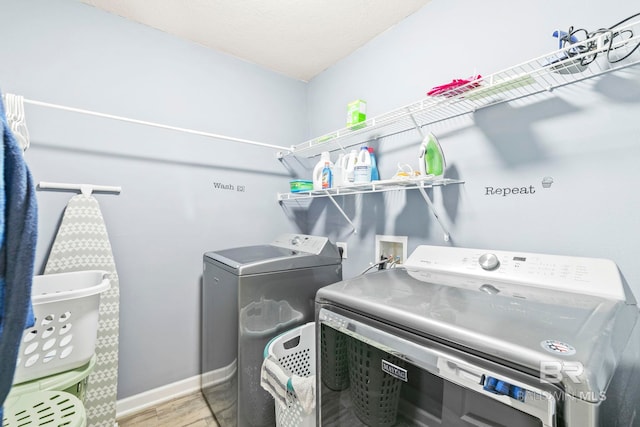 laundry area featuring independent washer and dryer and light wood-type flooring