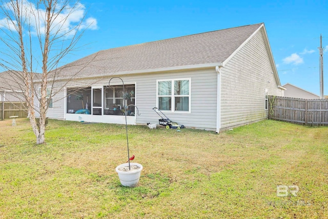 back of house with a lawn and a sunroom