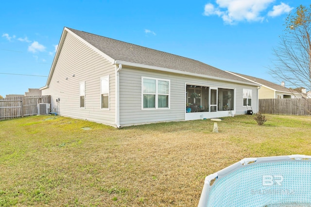 back of house with a fenced in pool, a lawn, and central AC unit