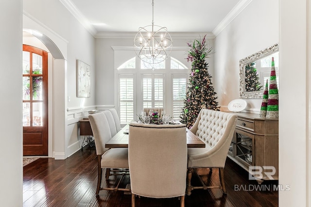 dining room with dark hardwood / wood-style floors, crown molding, and a chandelier