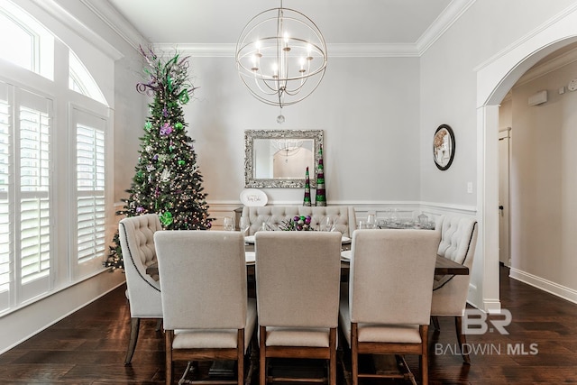 dining area with a chandelier, dark wood-type flooring, and ornamental molding