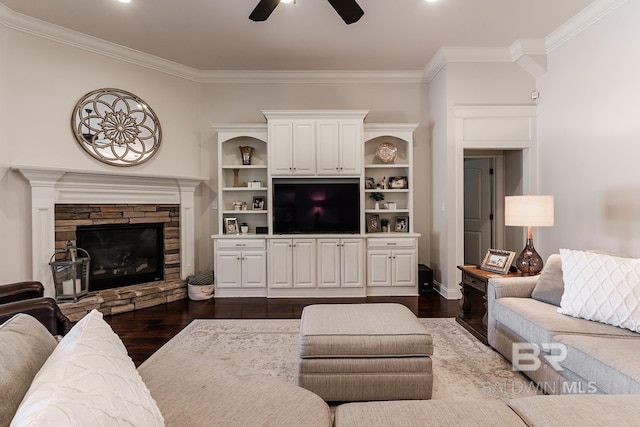 living room with dark hardwood / wood-style floors, ceiling fan, ornamental molding, and a fireplace