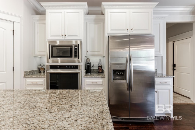 kitchen with light stone counters, white cabinetry, and appliances with stainless steel finishes