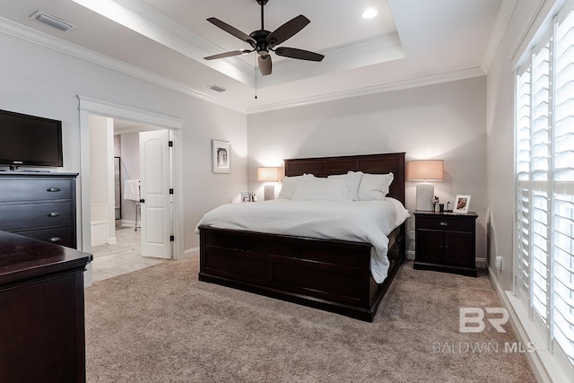 bedroom featuring ornamental molding, a tray ceiling, ceiling fan, and light colored carpet