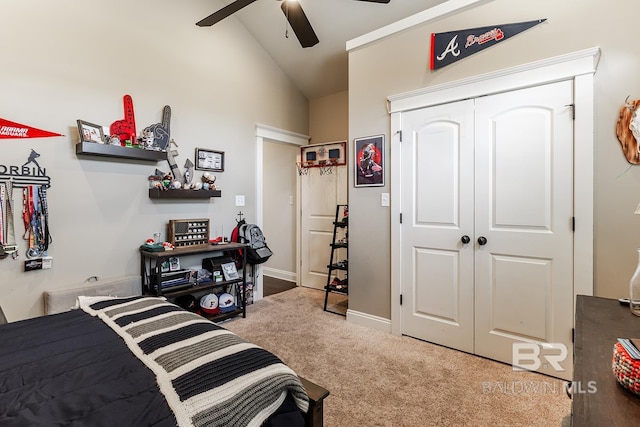 carpeted bedroom with a closet, vaulted ceiling, and ceiling fan