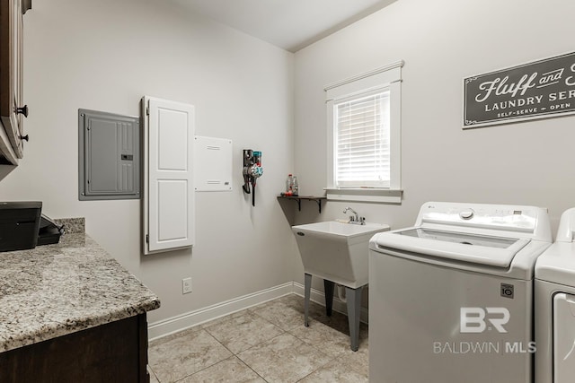 laundry room featuring electric panel, light tile patterned floors, cabinets, and independent washer and dryer