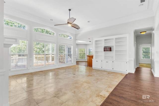 unfurnished living room featuring ornamental molding, built in shelves, light hardwood / wood-style floors, and ceiling fan