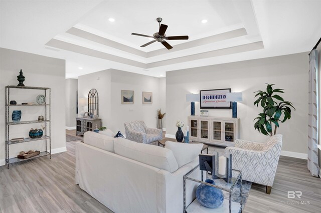 12753 Shoshoney Cir, Fairhope, AL 36532 - living room featuring a tray ceiling, baseboards, and ceiling fan
