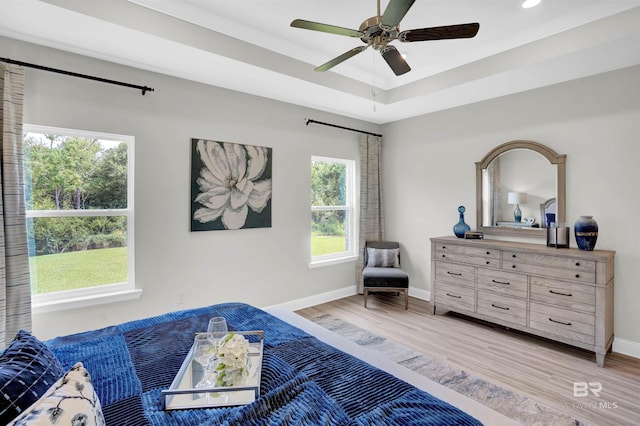 12753 Shoshoney Cir, Fairhope, AL 36532 - bedroom featuring a tray ceiling, baseboards, ceiling fan, and light wood finished floors
