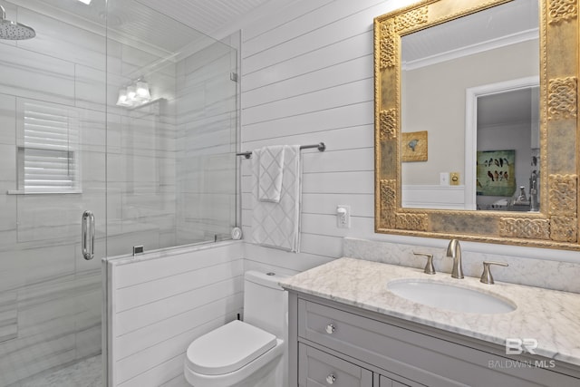 bathroom featuring vanity, crown molding, a shower with door, and toilet