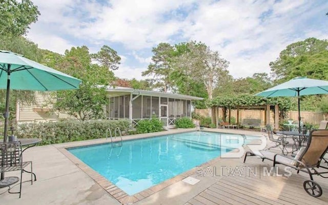 view of swimming pool with a patio area and a sunroom