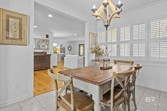 tiled dining room with an inviting chandelier and crown molding