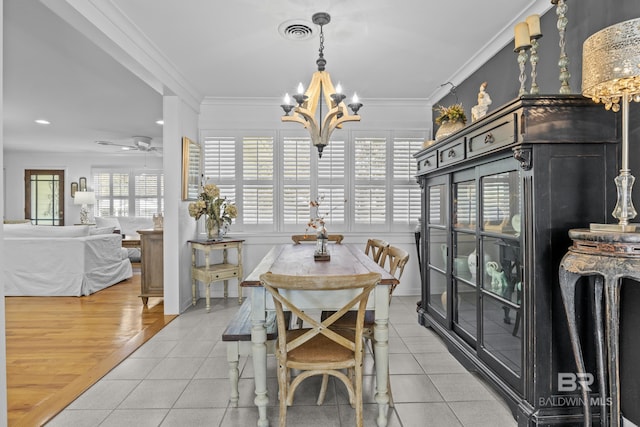 tiled dining area featuring crown molding and ceiling fan with notable chandelier