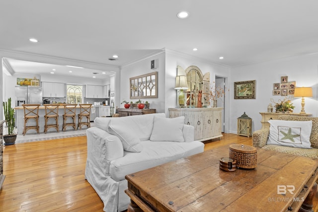 living room featuring crown molding and light hardwood / wood-style flooring