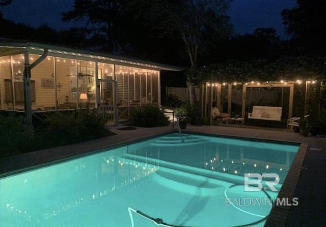 view of pool at twilight