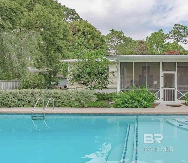 view of swimming pool with a sunroom