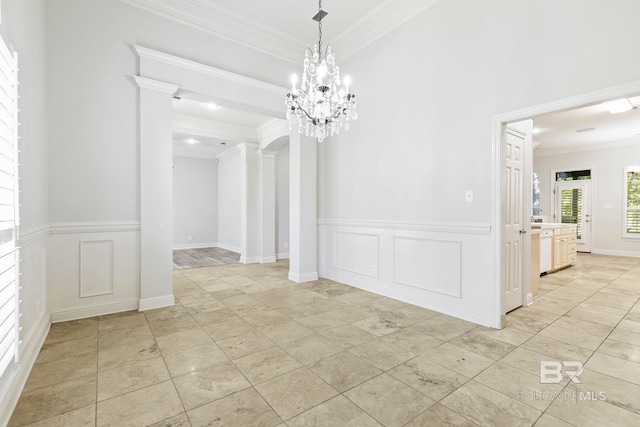 unfurnished dining area with light tile patterned floors, decorative columns, crown molding, and a notable chandelier