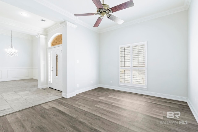 spare room with ceiling fan with notable chandelier, light hardwood / wood-style floors, and crown molding