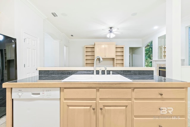 kitchen with dishwasher, light brown cabinets, a center island with sink, and sink