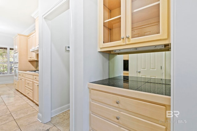 kitchen with light brown cabinets, white appliances, ornamental molding, and light tile patterned flooring