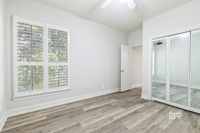 unfurnished bedroom with ceiling fan, a closet, and light wood-type flooring