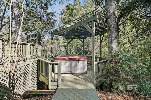 wooden terrace with ceiling fan, a pergola, and a hot tub