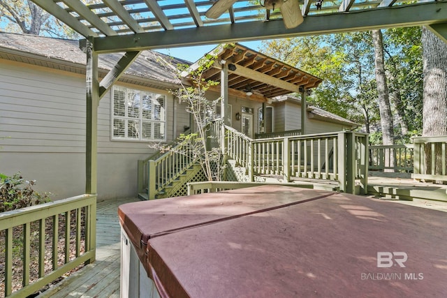 deck featuring a pergola, ceiling fan, and a hot tub