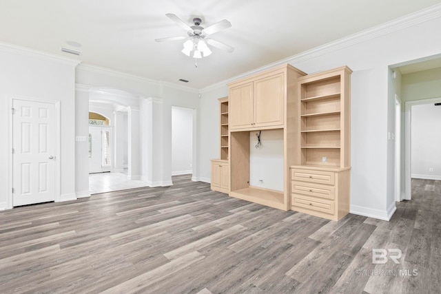 unfurnished living room featuring decorative columns, crown molding, ceiling fan, and hardwood / wood-style flooring