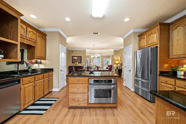 kitchen with stainless steel appliances, crown molding, sink, and pendant lighting