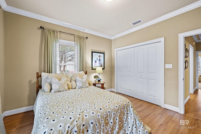 bedroom with crown molding, wood-type flooring, and a closet