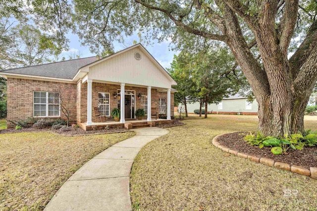 ranch-style home featuring a front lawn and covered porch