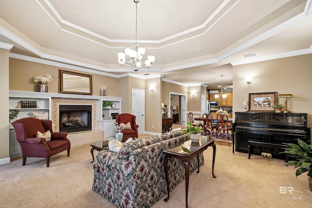 living room featuring a raised ceiling, light colored carpet, a notable chandelier, and a fireplace