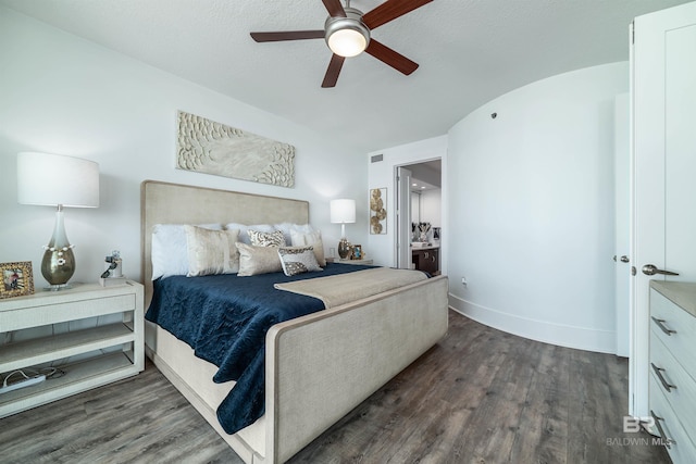 bedroom featuring a ceiling fan, baseboards, ensuite bathroom, visible vents, and dark wood-type flooring