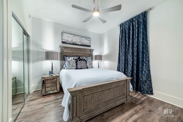 bedroom featuring ceiling fan, baseboards, a closet, and wood finished floors