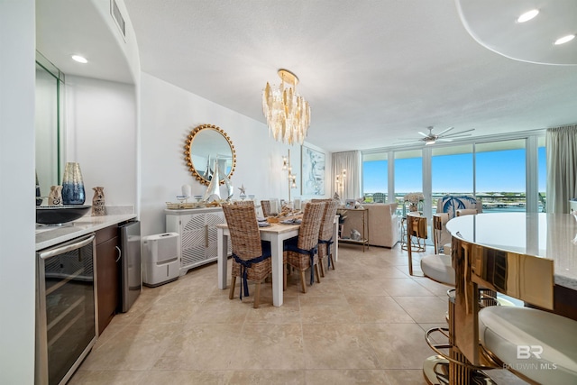 dining room with wine cooler, a wall of windows, ceiling fan with notable chandelier, and visible vents