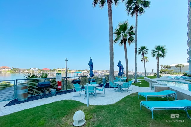 view of community with a yard, a patio, a pool, and a water view