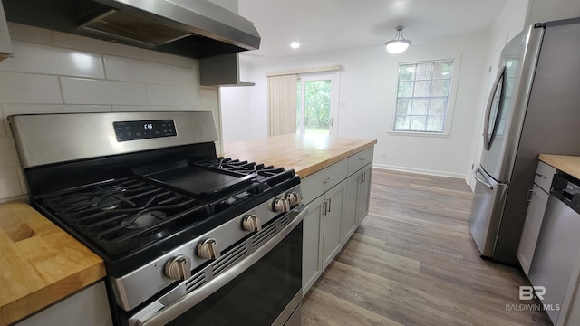 509 Pine St, Daphne, AL 36526 - kitchen with appliances with stainless steel finishes, butcher block counters, wall chimney range hood, light wood-style flooring, and recessed lighting
