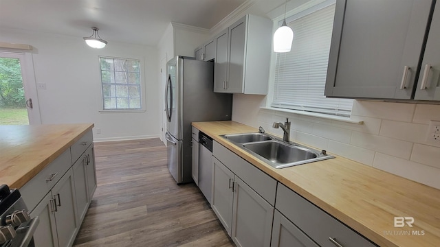 509 Pine St, Daphne, AL 36526 - kitchen with butcher block countertops, decorative backsplash, dark wood finished floors, stainless steel appliances, and hanging light fixtures