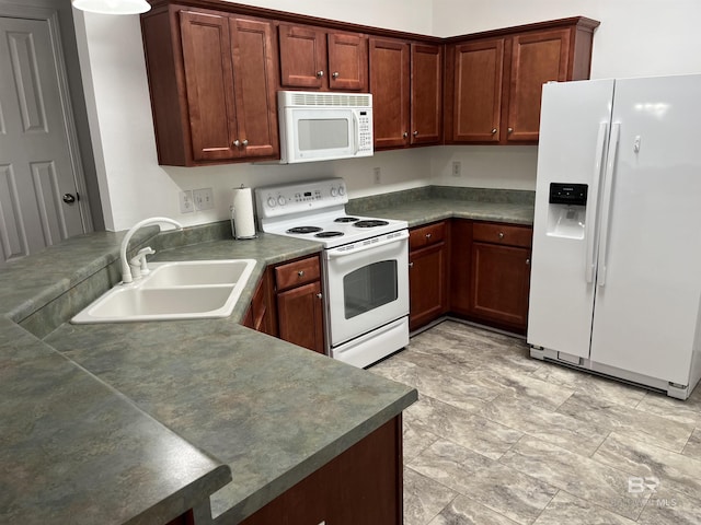 kitchen with kitchen peninsula, white appliances, and sink