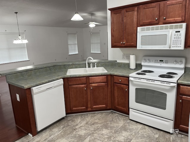 kitchen featuring pendant lighting, ceiling fan with notable chandelier, white appliances, and sink