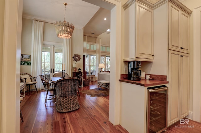 kitchen featuring decorative light fixtures, an inviting chandelier, hardwood / wood-style floors, and wine cooler