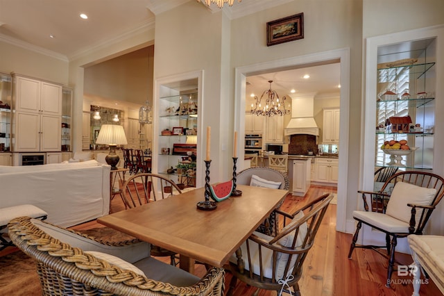 dining space featuring light hardwood / wood-style floors, a chandelier, and ornamental molding