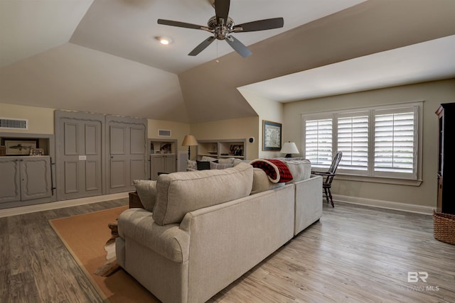 living room with ceiling fan, light hardwood / wood-style flooring, and lofted ceiling