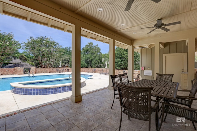 view of patio featuring ceiling fan and a pool with hot tub