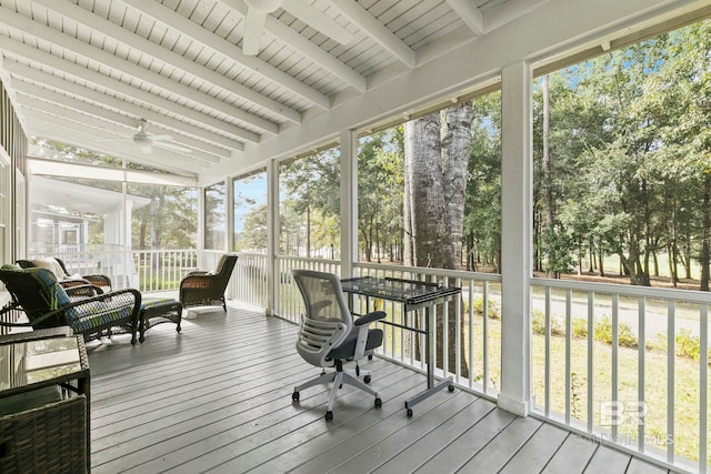 sunroom featuring ceiling fan, vaulted ceiling with beams, wooden ceiling, and a healthy amount of sunlight