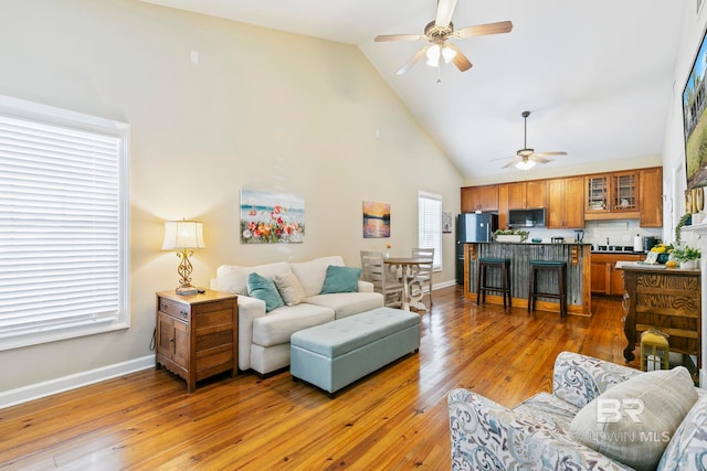 living room featuring high vaulted ceiling, hardwood / wood-style flooring, ceiling fan, and sink