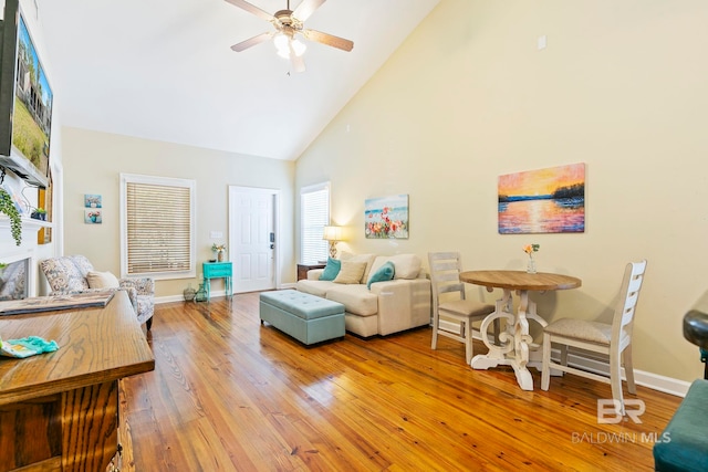 living room featuring hardwood / wood-style floors, ceiling fan, and high vaulted ceiling