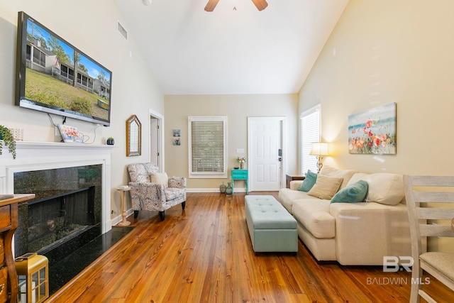 living room featuring high vaulted ceiling, hardwood / wood-style flooring, and ceiling fan